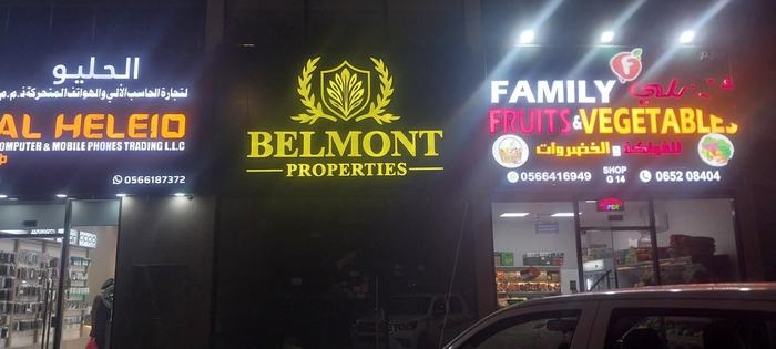 Belmont Properties and neighbouring illuminated shop signs at night