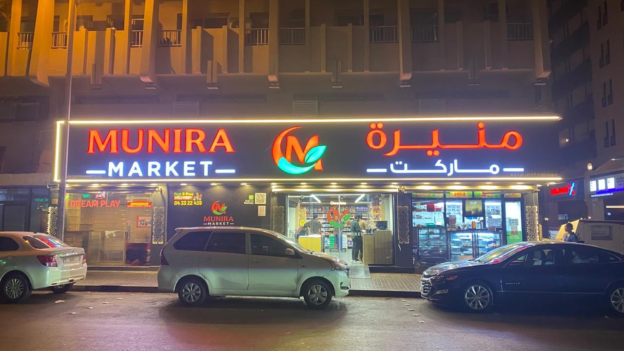 Munira Market illuminated shop sign at night